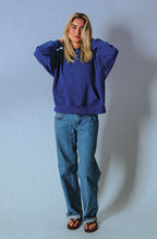 Front view of a model wearing the Soleil Lune Henley Hoodie in royal blue, featuring a relaxed oversized fit, drop shoulders, kangaroo pocket, and ribbed cuffs with light wash straight-leg jeans.