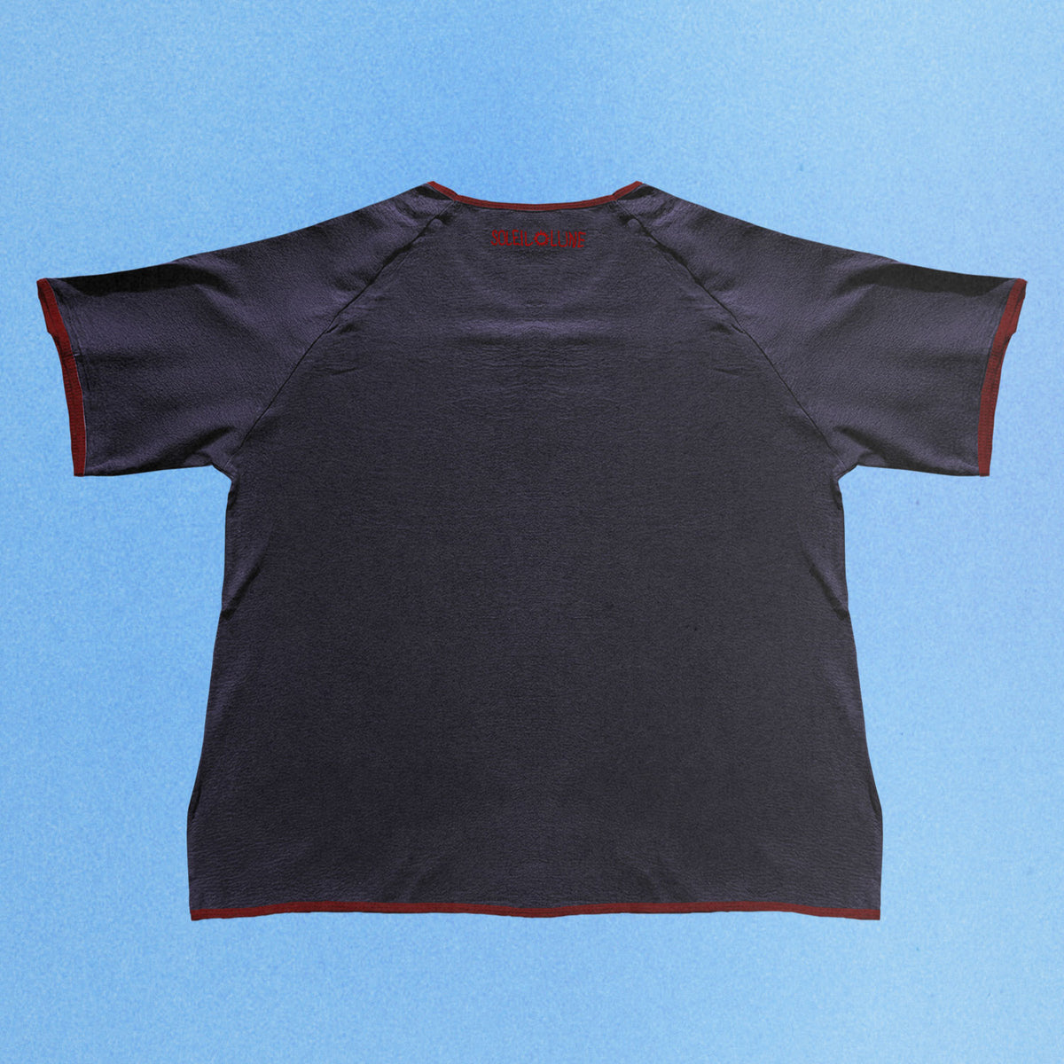 Navy hemp and organic cotton T shirt laid flat against a soft blue gradient background. The relaxed fit features raglan sleeves, subtle red contrast binding along the collar, sleeves, and hem, with a tonal Soleil Lune logo centered below the back neckline for a clean, understated finish.